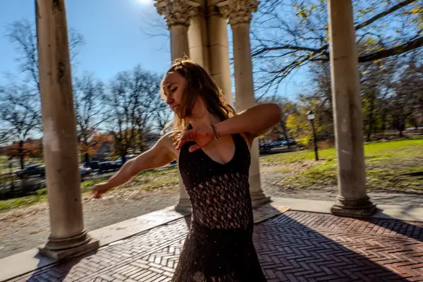 Lucy in dynamic arms-out mid-spin pose