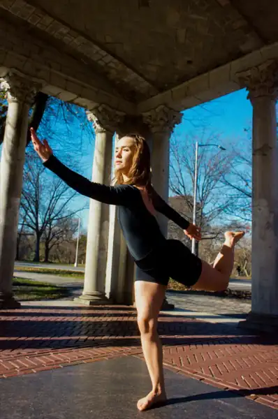 Lucy performing a high kick at columns, strong and graceful