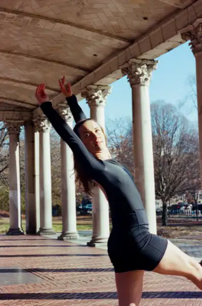 Lucy in a back pose at columns with arms raised elegantly