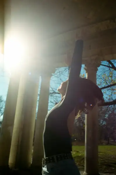 Silhouette with arm reaching up toward dramatic sun behind