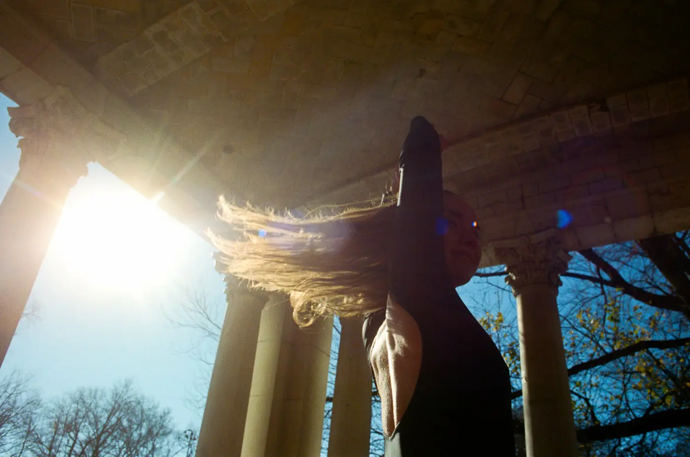 Dramatic backlit hair spin captured from below