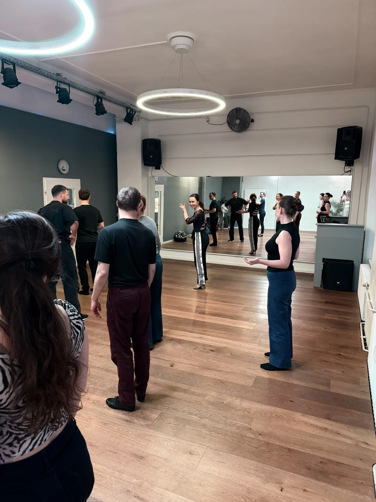 Wide view of the dance studio with students gathered around
