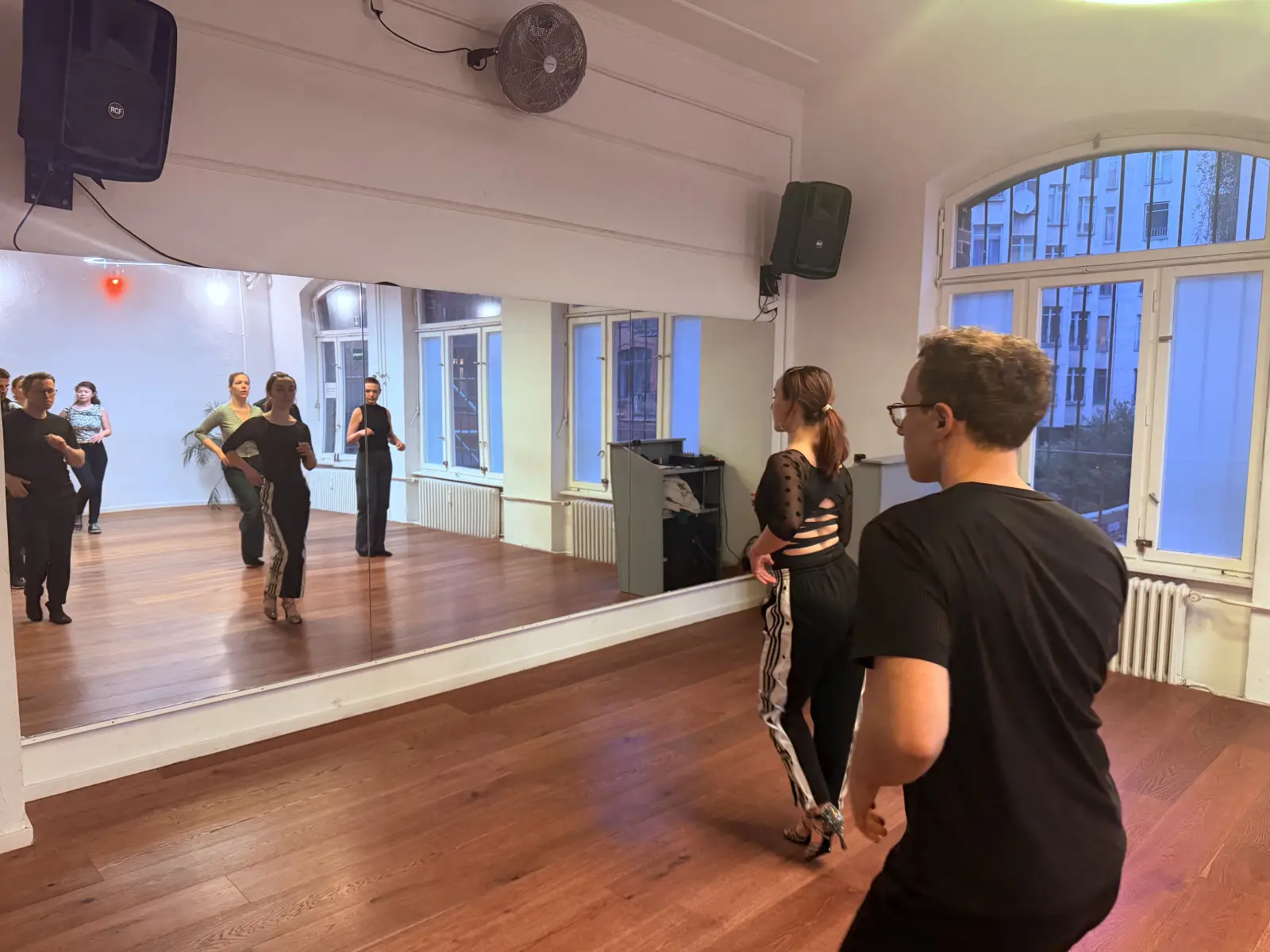 Students practicing across the mirror in open studio space