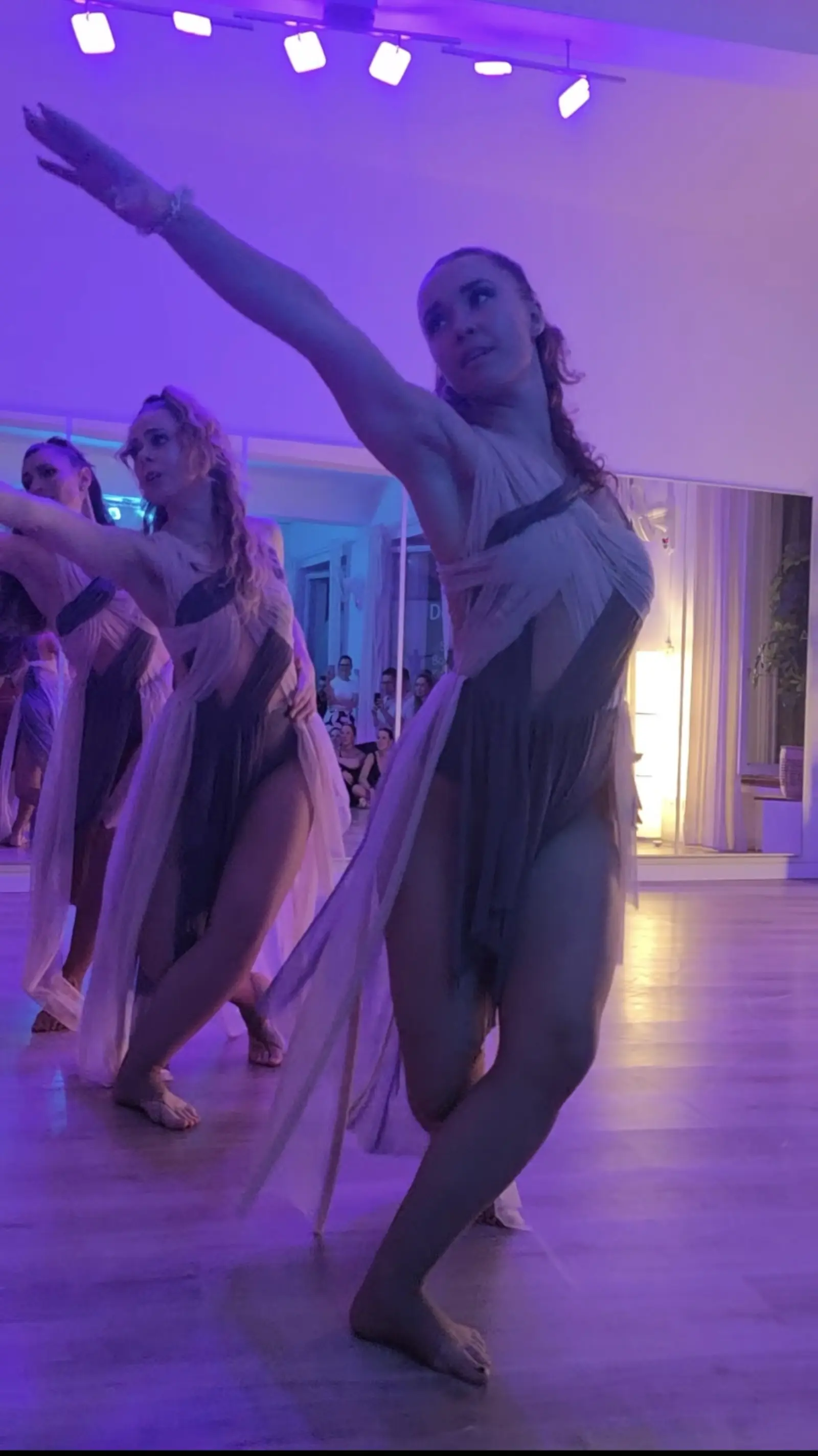 Ensemble performance in flowing costumes under theatrical light